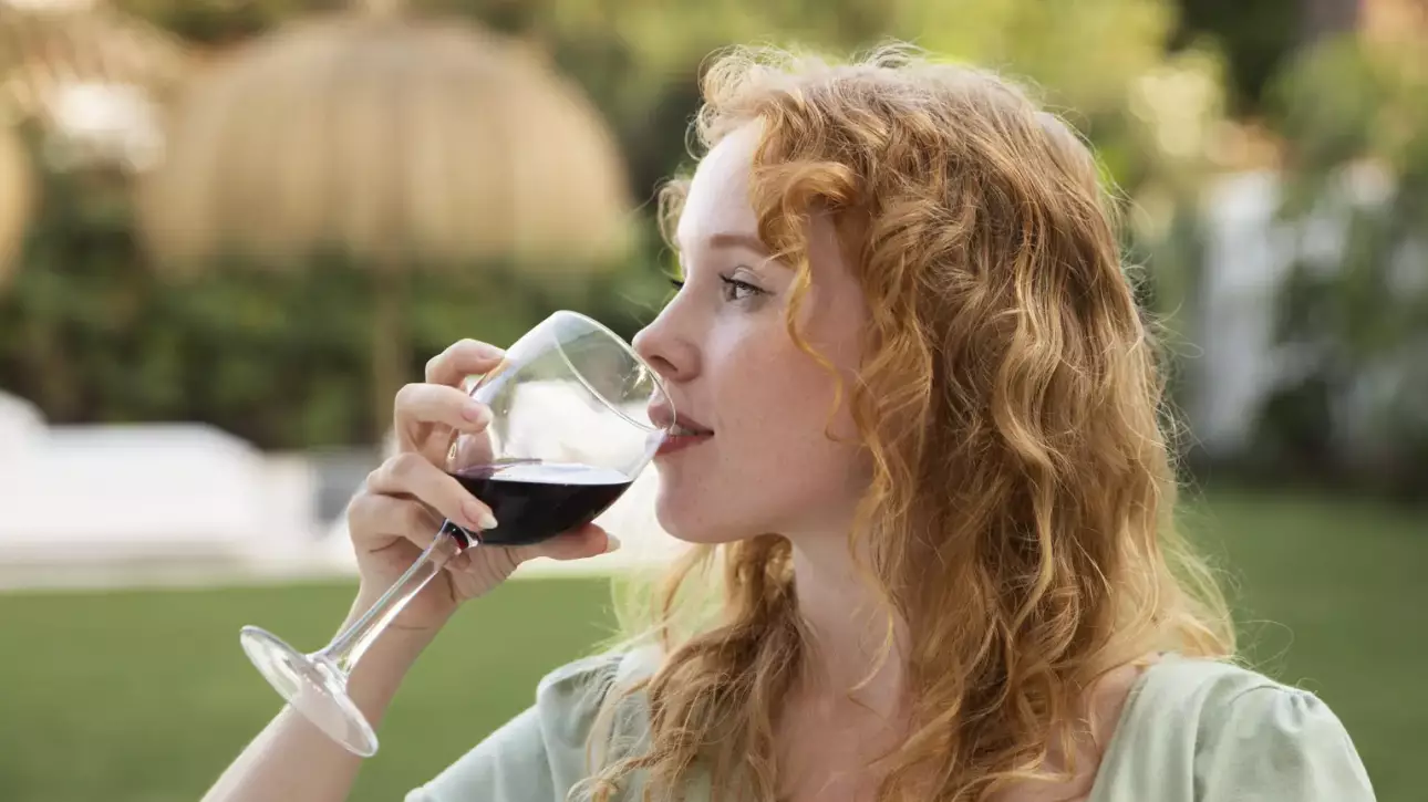 Mujer disfrutando de una copa de vino natural en un jardín