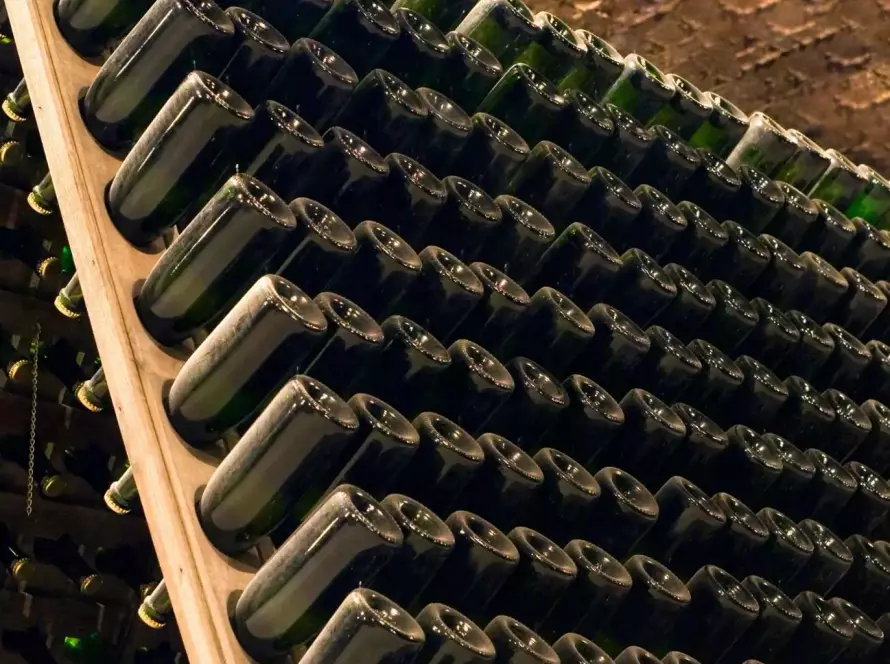 Botellas de vino espumoso natural Pet Nat reposando en posición invertida durante el proceso de elaboración tradicional.