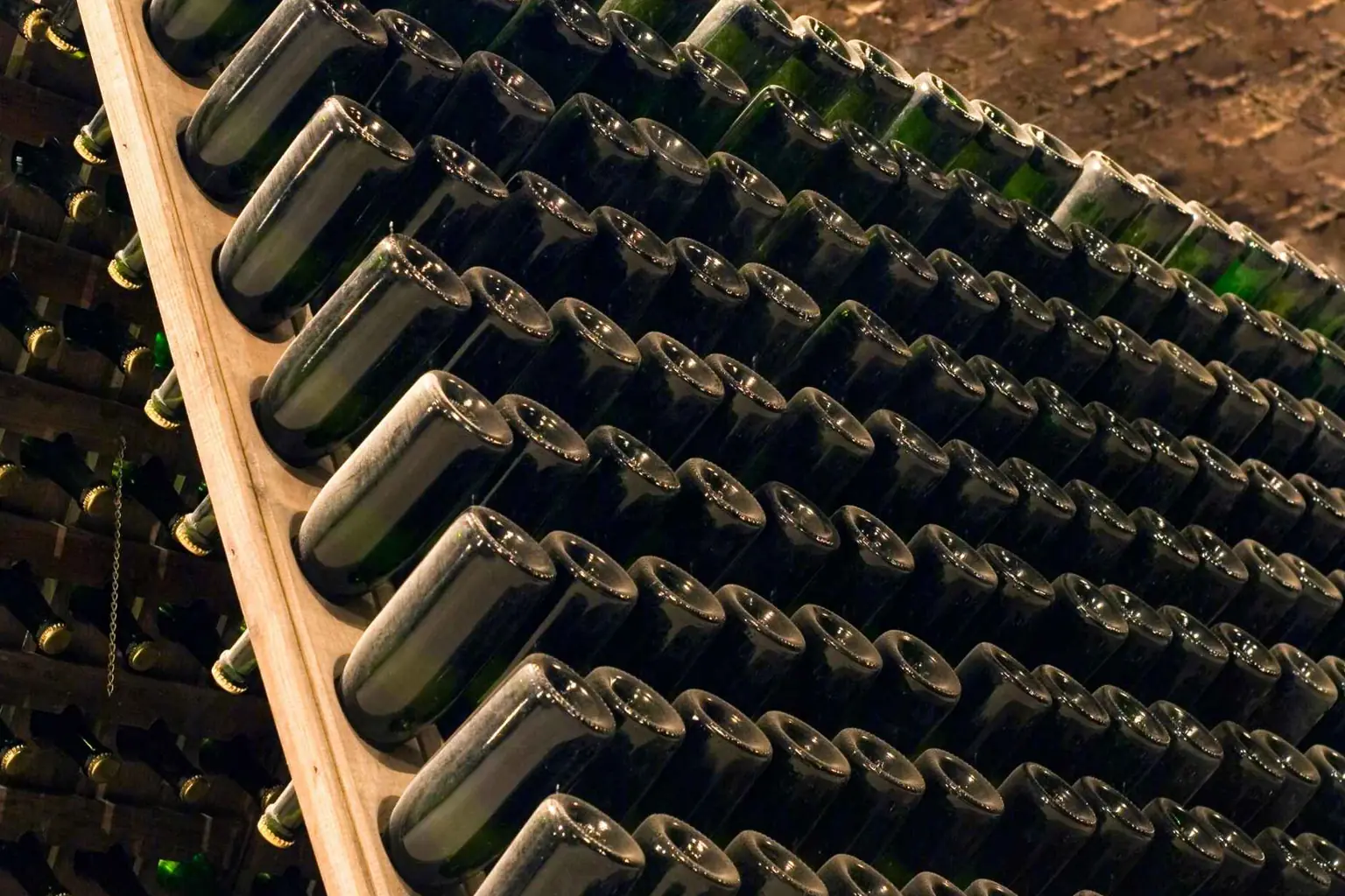 Botellas de vino espumoso natural Pet Nat reposando en posición invertida durante el proceso de elaboración tradicional.