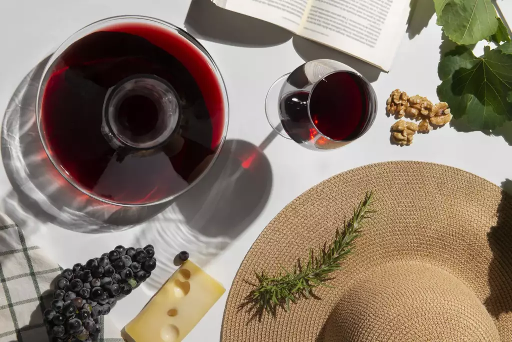 Vista cenital de vino natural acompañado de queso, uvas y frutos secos